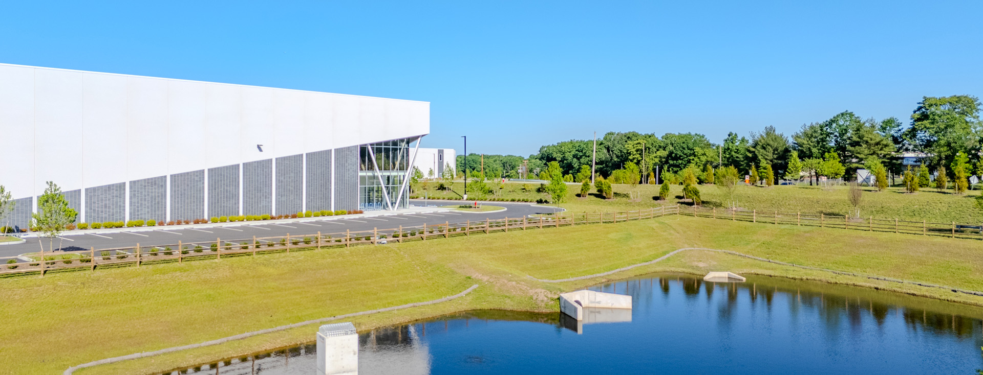 Drone image of side view of one of Arsenal Trade Center's three industrial buildings with pond.