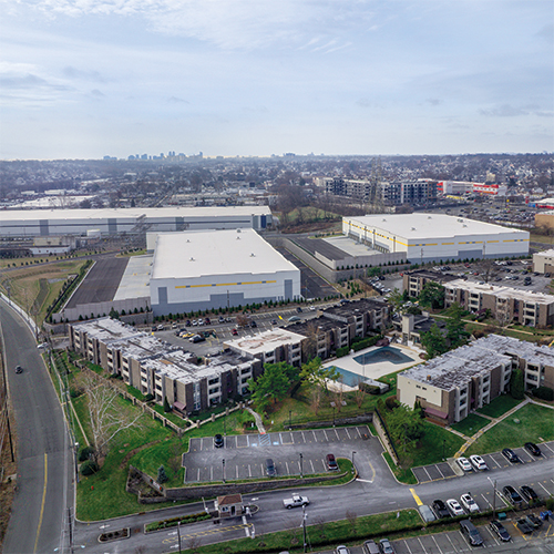 Drone view of Lincoln Logistics in Belleville, a two-building industrial construction including a water tank and river backdrop.