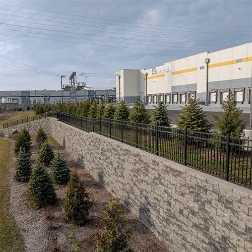 Drone photo with angle view of dock area with large retaining wall and landscaping spanning the docks