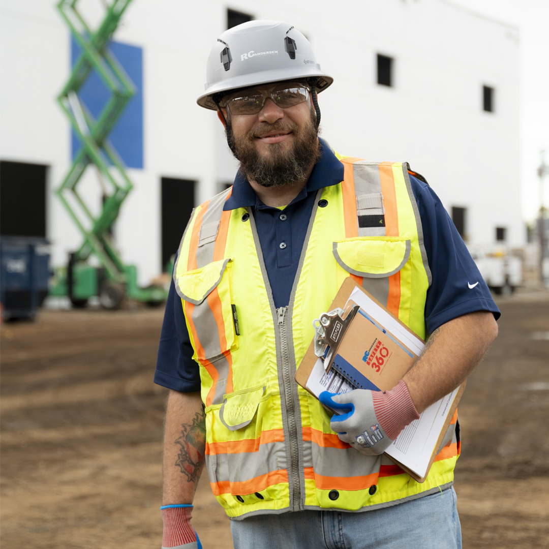 RCA Employee in full PPE on an active industrial jobsite with scissor lift in background