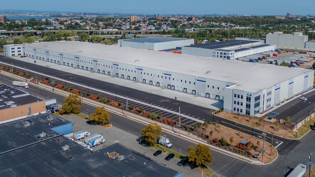 Arial/drone image of completed industrial project from the rear view of loading docks and surrounding cityscape backdrop